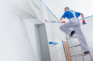 commercial painting and renovation with contractor on ladder