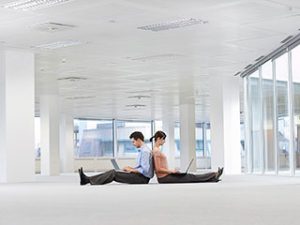 two office managers reviewing office renovation tips in high-rise office building