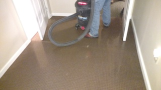 water damage restoration service showing contractor with shop vac
