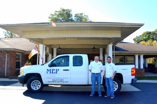 professional mep contractors stand in front of truck after commercial remodeling project