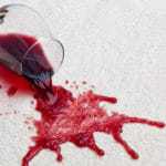 Alfombra manchada de vino tinto en revestimientos de suelo de hotel.